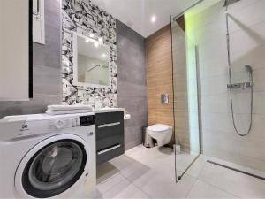 a bathroom with a washing machine and a shower at Apartament Bryza Aquarius - z miejscem parkingowym in Ustka +4 photos