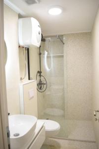 a bathroom with a sink and a toilet and a shower at Traveler’s home in Visoko