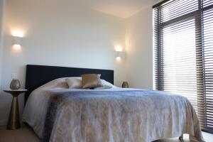 una camera da letto con un letto con una coperta blu e una finestra di Brand New Apartment Sint-niklaas a Sint-Niklaas