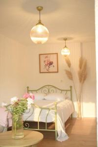 a bedroom with a bed and a table with flowers at Traveler’s home in Visoko