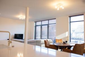 a living room with a table and a couch at Brand New Apartment Sint-niklaas in Sint-Niklaas