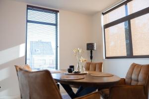 una sala da pranzo con tavolo e sedie in legno di Brand New Apartment Sint-niklaas a Sint-Niklaas