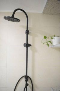 a black pole with a light on a wall at Traveler’s home in Visoko