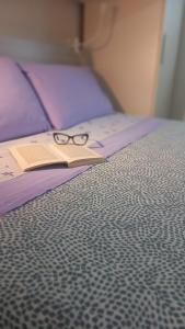 un par de gafas sentadas encima de una cama en Monolocale Azzurra en Magione