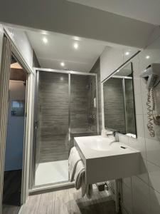 a bathroom with a sink and a shower at Hôtel De Troyes in Troyes