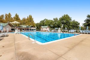 a large swimming pool with chairs and an umbrella at Bear Trap Dunes --- 34 Sycamore Street in Ocean View