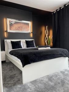 a large white bed in a bedroom with a black wall at Flat 1 in Lampeter