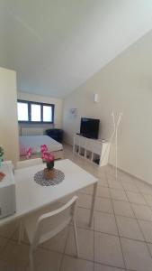 sala de estar con mesa blanca y sofá en Monolocale Azzurra en Magione