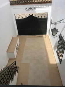 a hallway with a large black door and stairs at LAS LANZAS in Sabiote