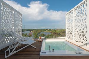 a hot tub on a deck with a view of the water at Hotel Oasi Di Kufra in Sabaudia