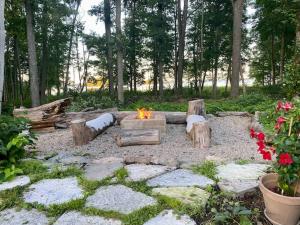 a fire pit in the middle of a yard with trees at Spacious house near water and nature in Odensbacken