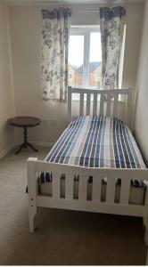 Un dormitorio con una cama y una mesa y una ventana. en Salimi, en Bridgend