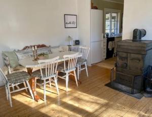 a kitchen and dining room with a table and chairs at Spacious house near water and nature in Odensbacken