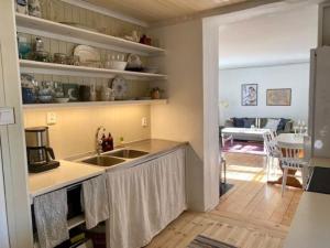 a kitchen with a sink and a living room at Spacious house near water and nature in Odensbacken