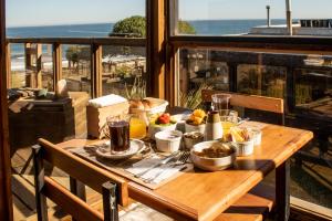 un tavolo con cibo sul balcone di Ruka Antu Ecolodge a Cobquecura