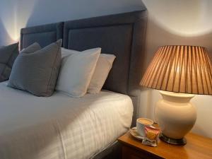 a bedroom with a bed with a lamp on a table at The Oaks Hotel in Alnwick