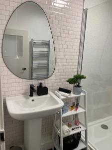 a bathroom with a white sink and a mirror at Flat 1 in Lampeter