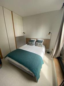 a bedroom with a bed with a green blanket at Maison d'architecte décorée avec soin in La Baule