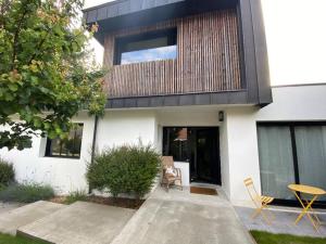 a house with a wooden facade with a patio at Maison d'architecte décorée avec soin in La Baule