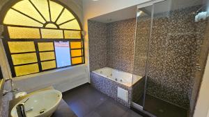 y baño con ducha, lavabo y bañera. en La Llave 351, en Cusco
