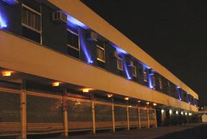 un edificio con luci blu sopra di esso di notte di Status Motel a Niterói