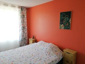 a bedroom with orange walls and a bed and a window at Au petit Bonheur, centre St-Raphaël, 8min à pied plage in Saint-Raphaël