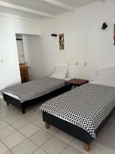 two beds sitting next to each other in a room at Villa des Pêcheurs Beach Hôtel in Cap Skirring