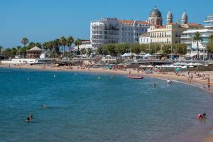 a group of people swimming in the water at a beach at Au petit Bonheur, centre St-Raphaël, 8min à pied plage in Saint-Raphaël