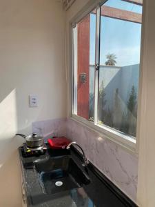 a sink in a kitchen with a window at Bangalô Miraflores in Chapada dos Guimarães