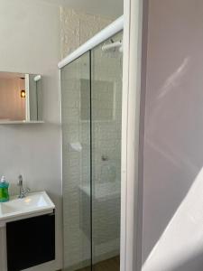 a bathroom with a glass shower and a sink at Bangalô Miraflores in Chapada dos Guimarães