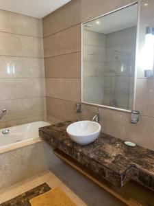 y baño con lavabo, bañera y espejo. en Belle Villa à Bouznika plage - Golf Bouzbay en Bouznika