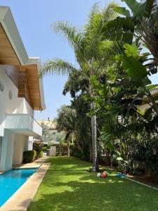 um quintal com uma piscina ao lado de uma casa em Belle Villa à Bouznika plage - Golf Bouzbay em Bouznika