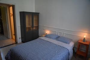 Le Piercot في لييج: غرفة نوم مع سرير مع وسادتين زرقاوين