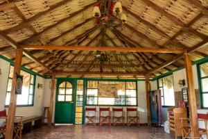 Habitación grande con techo de madera y sillas. en Cabaña Campestre La Esperanza, en Duitama