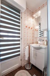 uma casa de banho com um lavatório branco e uma janela em Mjesto za odmor Golden Hill 