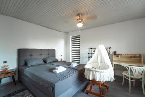 a bedroom with a bed with a chair and a table at Mjesto za odmor Golden Hill in Šandrovac