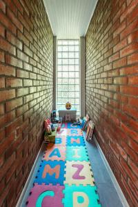 a room with a brick wall and a rug with letters at Mjesto za odmor Golden Hill in Šandrovac