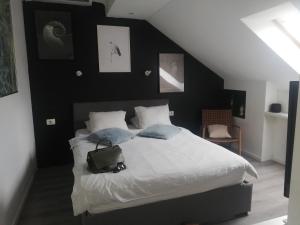 een slaapkamer met een bed met witte lakens en blauwe kussens bij Apartments Simple Teslina in Zagreb
