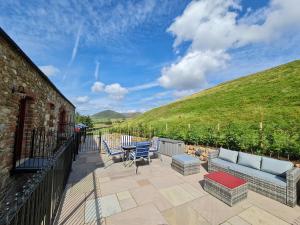a patio with a couch and chairs on a balcony at Whinstone in Keisley
