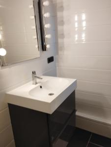 a bathroom with a white sink and a mirror at La cinéroom in Bon-Encontre