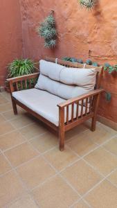 a wooden bench with three pillows on top of it at Casa Mamatita in Agüimes