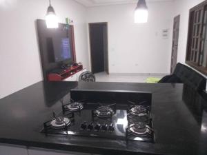 a kitchen with a stove top in a living room at Casa em Praia Grande Litoral sul in Praia Grande +4 photos