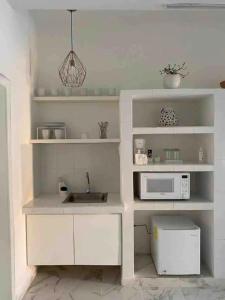 a white kitchen with a sink and a microwave at Casa Mercedes in Valladolid
