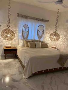 sypialnia z dużym łóżkiem i 2 żyrandolami w obiekcie Casa Mercedes w mieście Valladolid