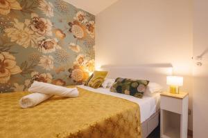 a bedroom with two beds and a wall with flowers at Le Balcon du 21 in Bourg-en-Bresse