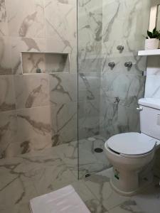 a bathroom with a toilet and a glass shower at Casa Mercedes in Valladolid +22 photos