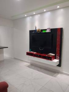 a flat screen tv on a wall in a room at Casa em Praia Grande Litoral sul in Praia Grande