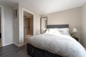 a bedroom with a large bed and a walk in shower at Belfast Quarters: 10th Floor Gem in Belfast