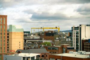 a city skyline with buildings and a yellow crane at Belfast Quarters: 10th Floor Gem in Belfast