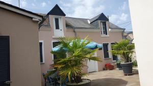 a house with palm trees in front of it at Maison avec garage 24 HEURES CAMIONS et toute manifestation pour 4 personnes in Le Mans